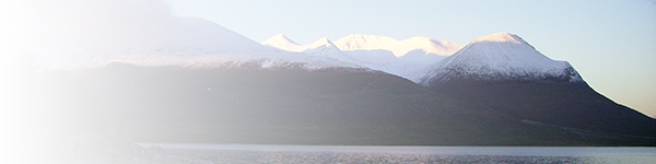 Snöklädda berg vid hav